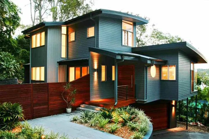 Modern home with professional house exterior painting in dark grey cladding and warm accent lighting