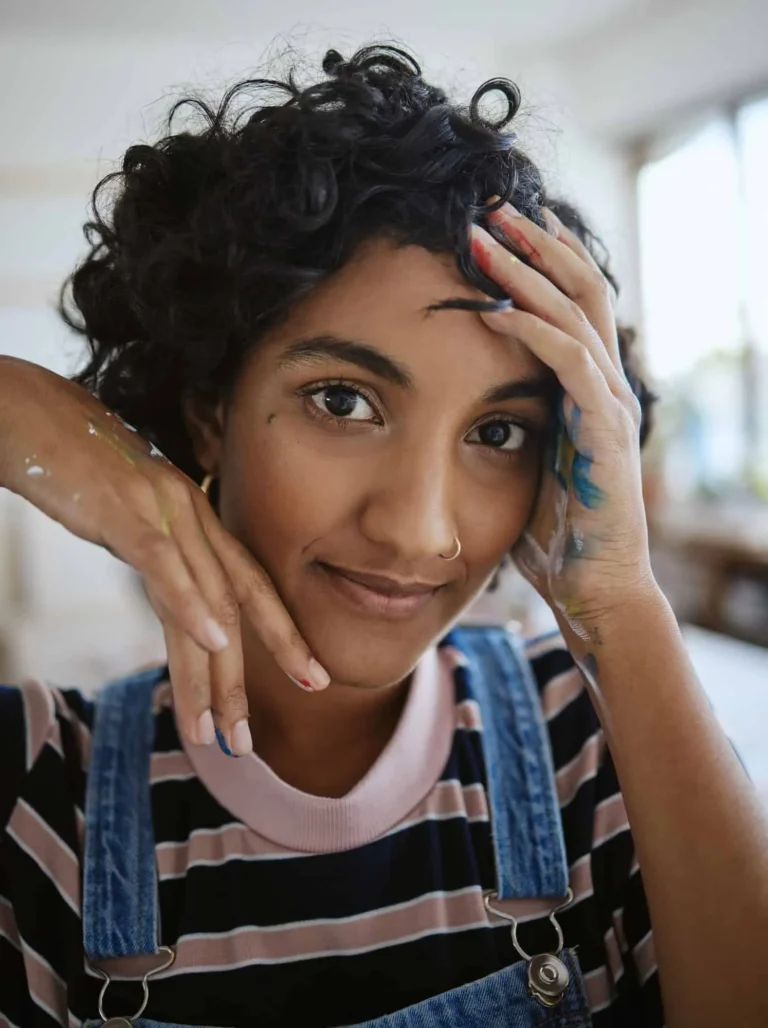 Smiling woman with paint on hands representing professional interior painting services